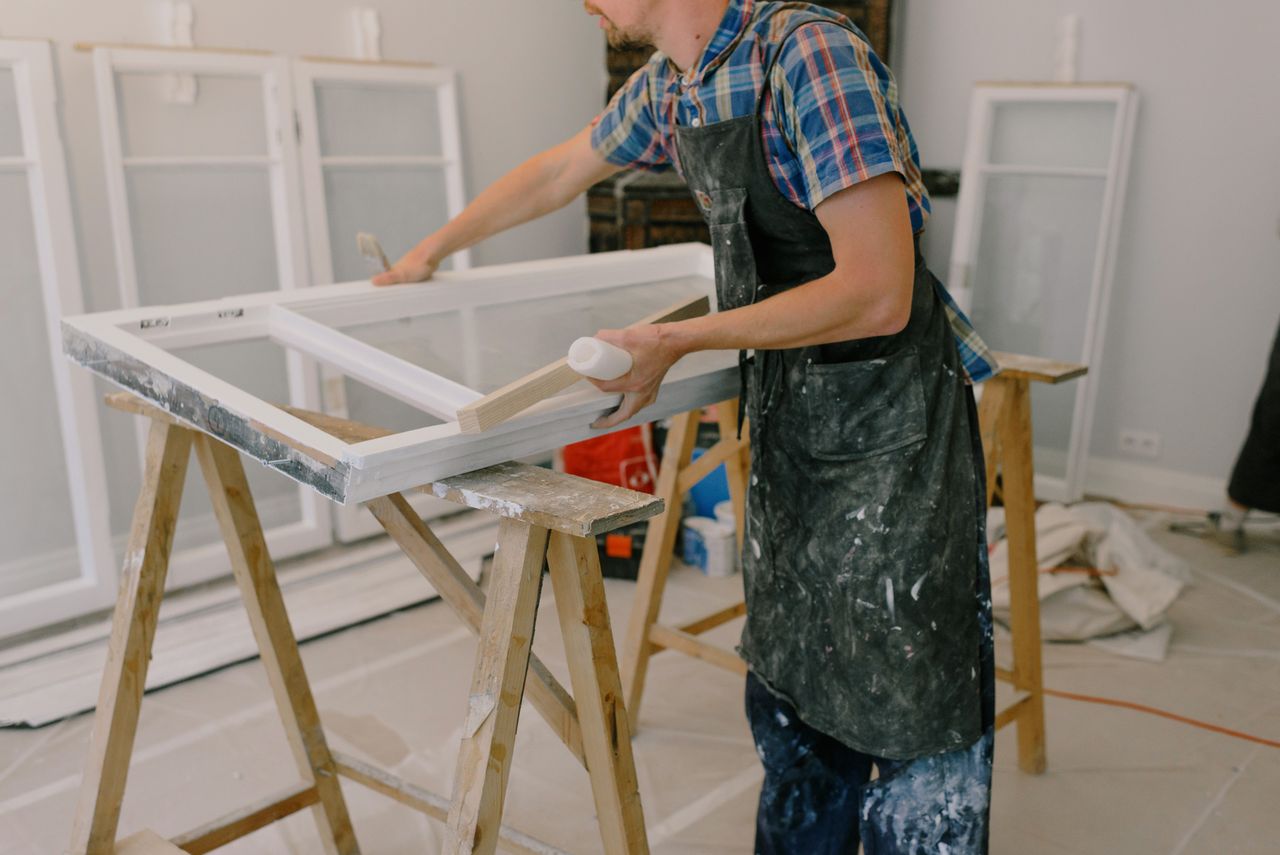 Crafting Captivating Headlines: Your awesome post title goes here Unrecognizable male master wearing dirty apron standing near window with white frames on wooden workbench while working in professional studio