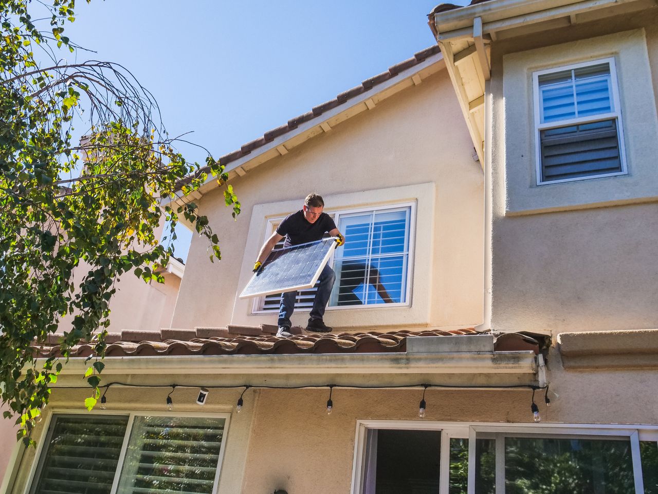 The Art of Drawing Readers In: Your attractive post title goes here A solar technician installing panels on a house roof, emphasizing renewable energy.